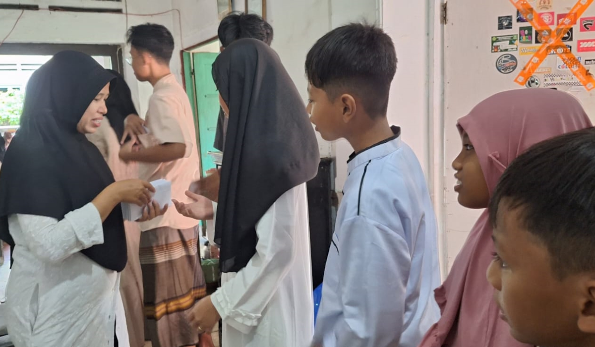 Seorang ibu di Kelurahan Pasarbatang, Kabupaten Brebes, sedang membagikan amplop pecingan kepada anak-anak kerabatnya. 