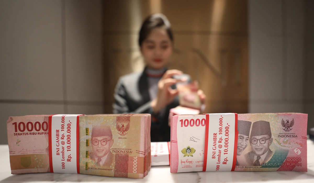 Petugas menunjukkan mata uang rupiah di salah satu kantor cabang PT Bank Negara Indonesia (BNI) Tbk. di Jakarta 