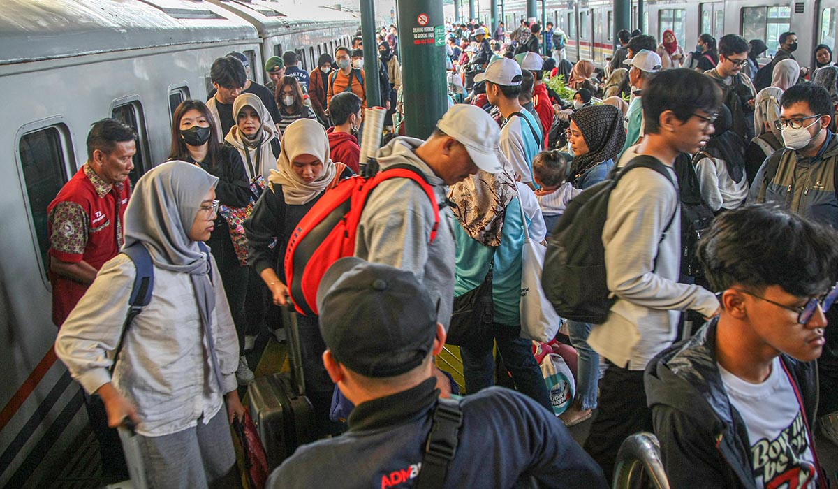 Para penumpang antre memasuki kereta api di Stasiun Gambir, Jakarta, Minggu (7/4).
