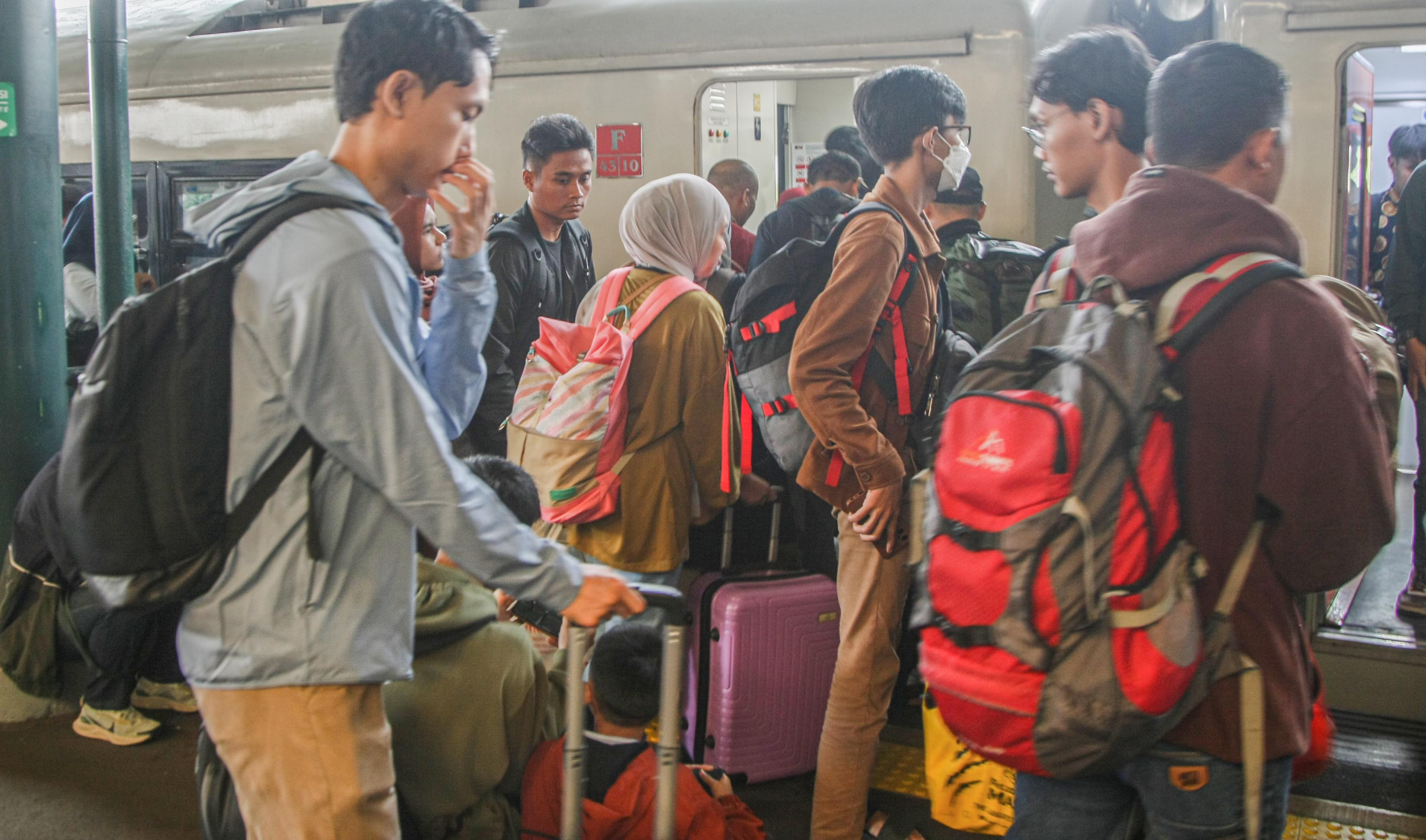 Para penumpang antre memasuki gerbong kereta api eksekutif Argo Dwipangga