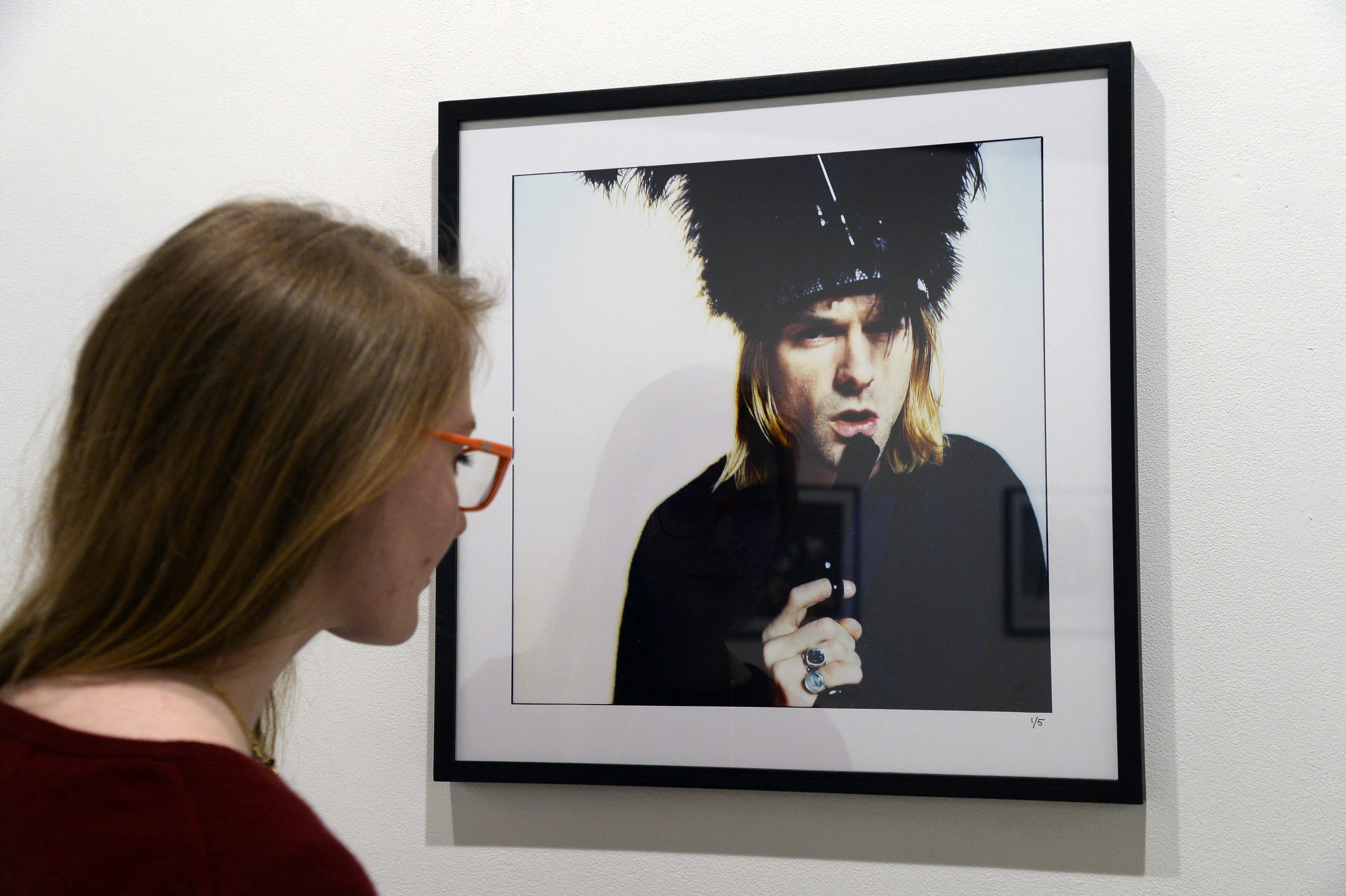 Seorang perempuan melihat foto mendiang Kurt Cobain bertajuk 'The Last Shooting' di Addict Gallery, Paris, 28 Maret 2024