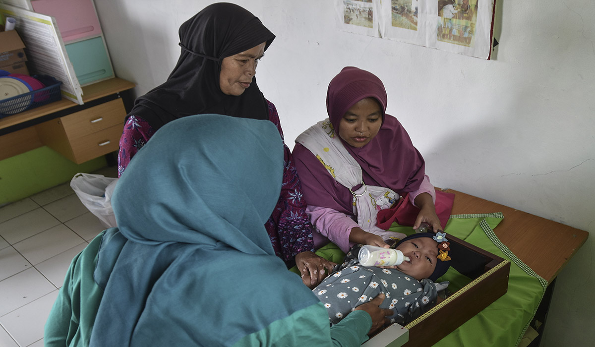 Kader posyandu Mawar memberi susu ke anak saat posayandu di Darmaraja, Kabupaten Ciamis, Jawa Barat, Selasa (16/1).