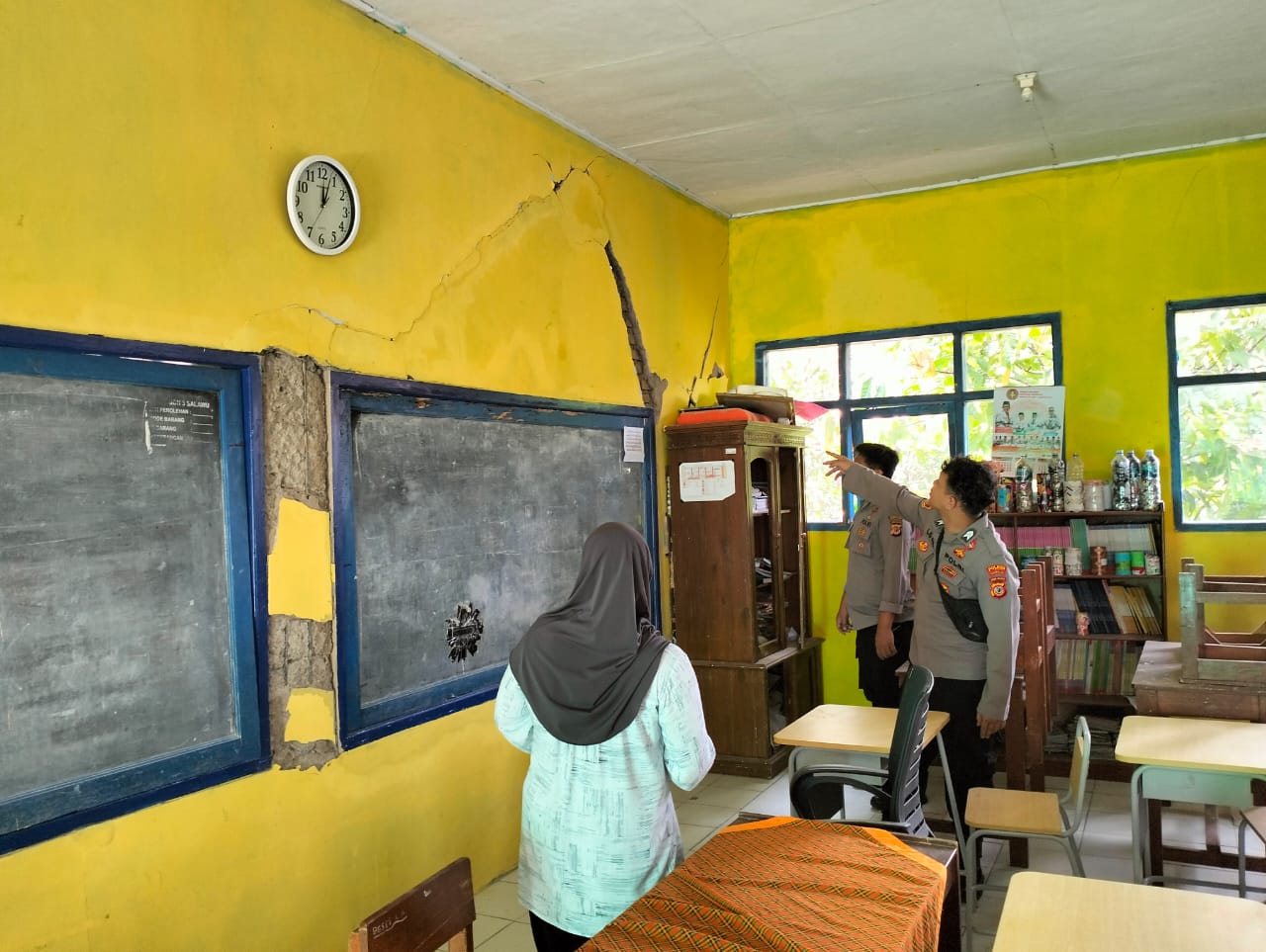 Petugas memeriksa ruangan kelas yang terdampak gempa. 