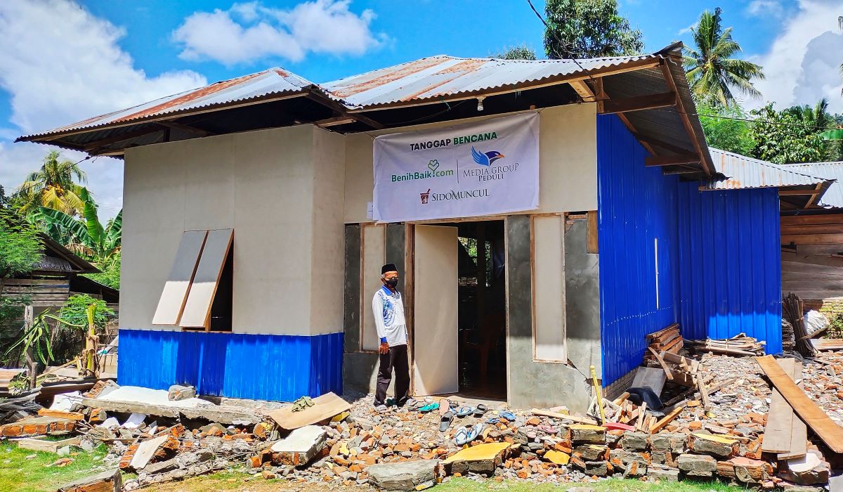 Seorang warga terdampak gempa berdiri di depan bangunan hunian sementara (huntara) bantuan dari Media Group Peduli.