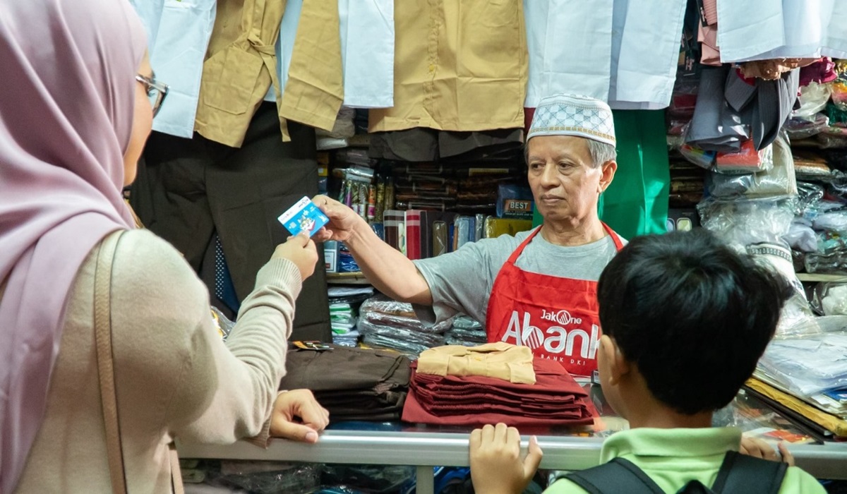 Pedagang pakaian, yang juga Agen JakOne Abank, tengah melayani pelanggan di Pasar Santa, Jakarta Selatan, Selasa (30/4).