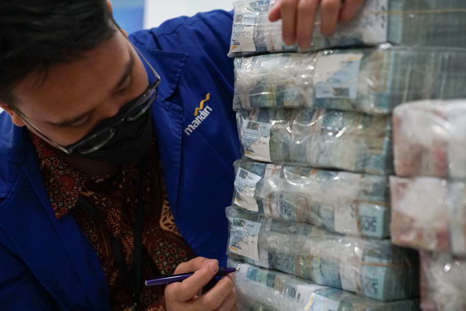 Petugas Bank Mandiri menyiapkan uang tunai untuk masyarakat di Jawa Barat