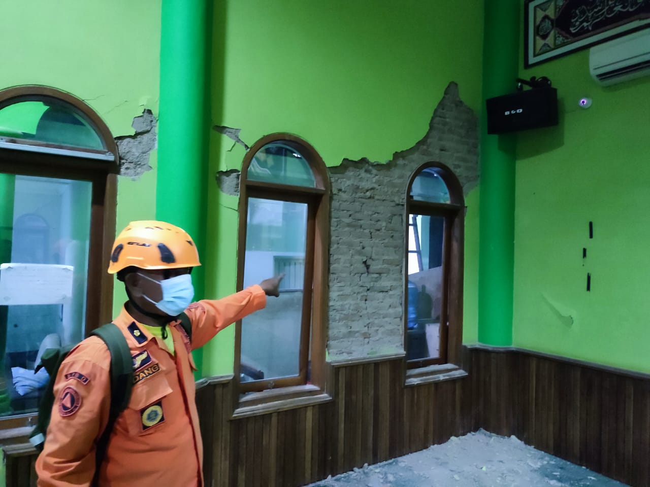 Seorang petugas BPBD menunjukkan kerusakan yang terjadi di salah satu tempat ibadah