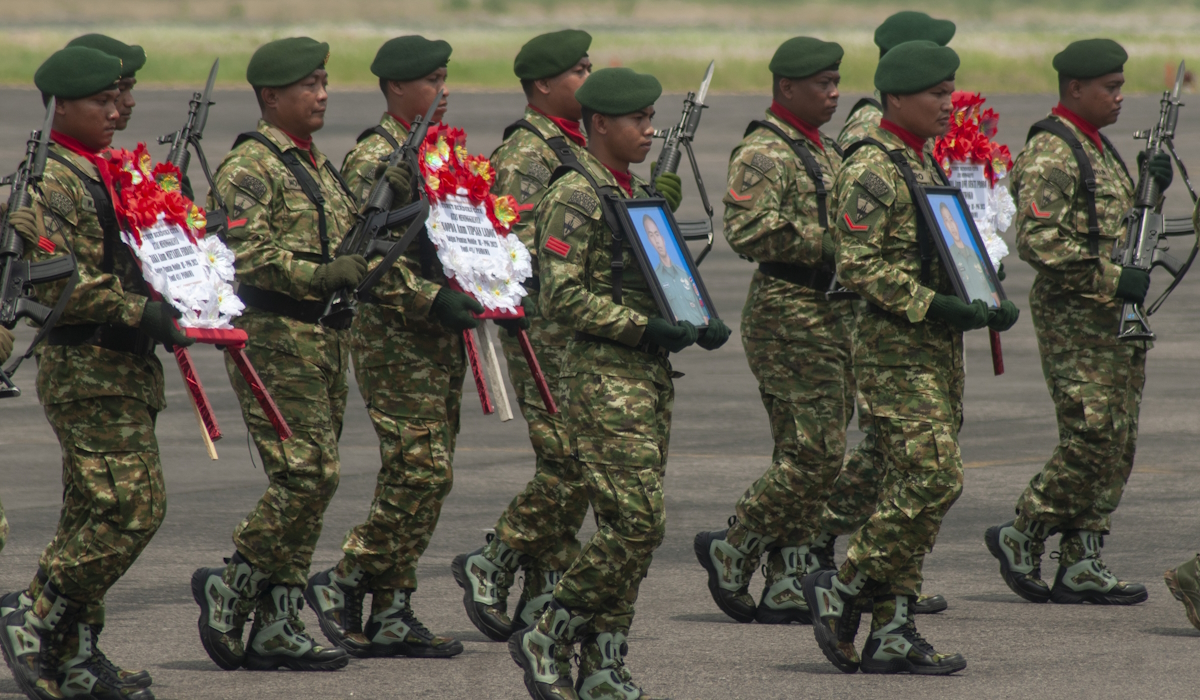 Sejumlah prajurit TNI AD membawa karangan bungan dan foto prajurit TNI AD yang gugur di Papua saat tiba di Lanud Adi Soemarmo