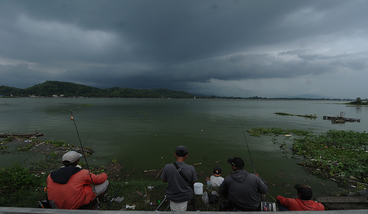 Sejumlah warga memancing ikan di Rowo Jombor yang diselimuti awan gelap di Klaten, Jawa Tengah, Rabu (16/11/2022).