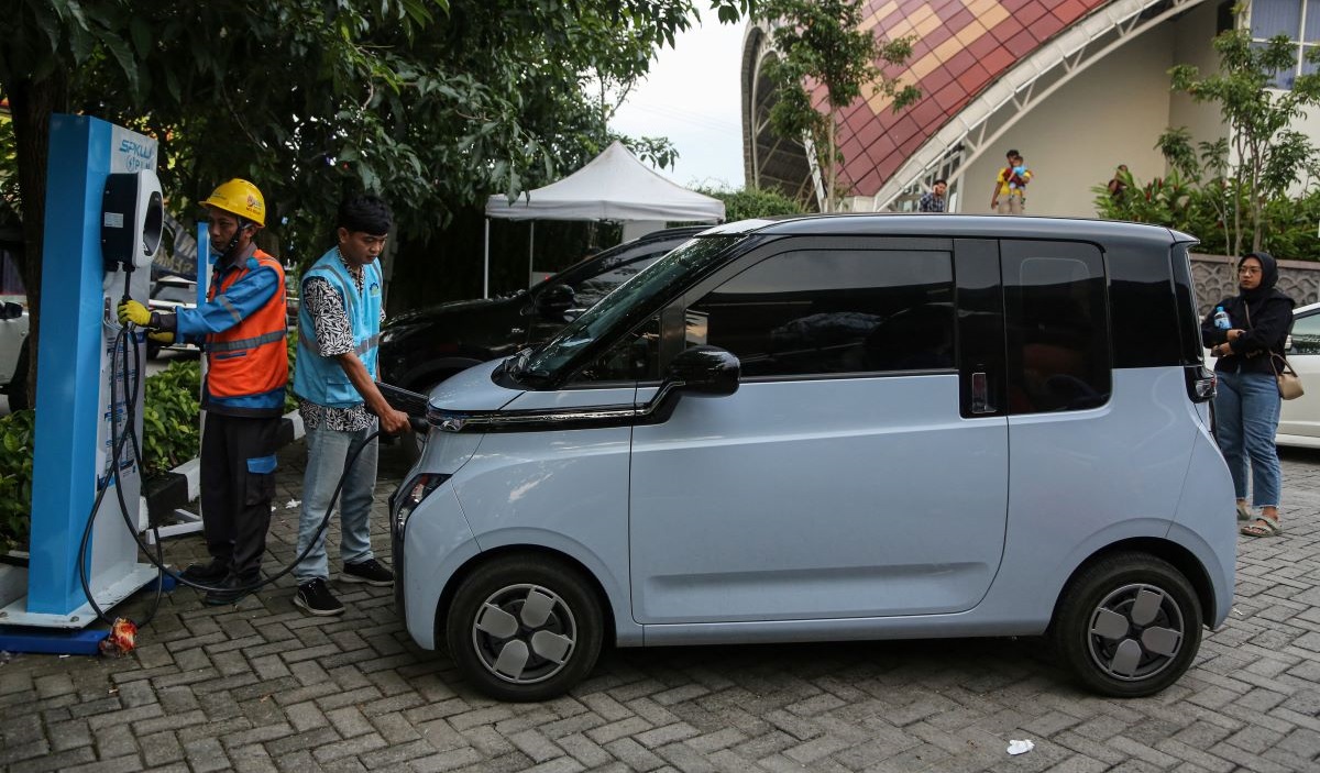 Sejumlah petugas membantu pengisian ulang mobil listrik pemudik di SPKLU Rest Area 429, Ungaran, Kabupaten Semarang, Minggu (7/4/2024).