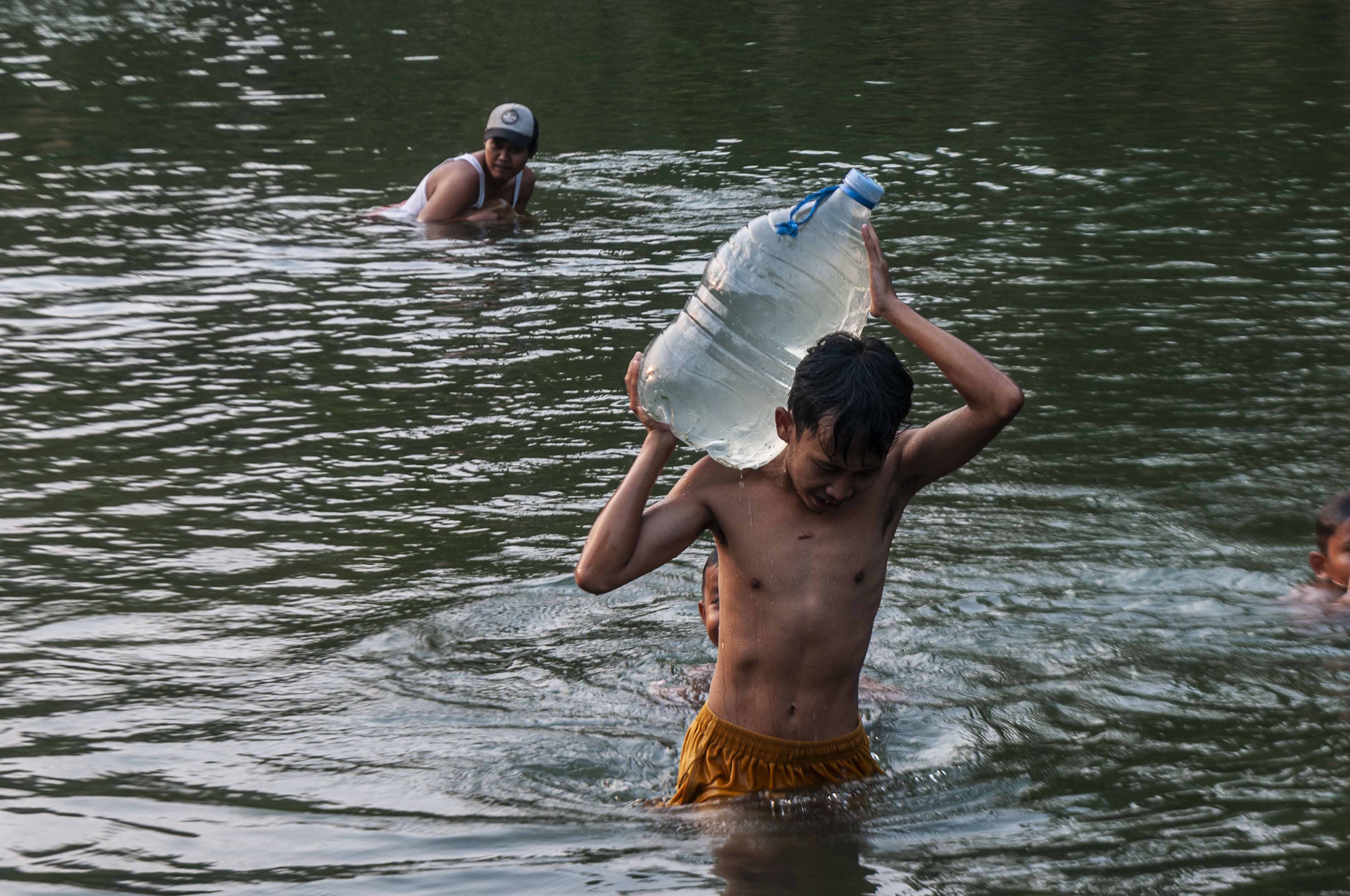 Seorang anak membawa galon berisi air dari Sungai Ciberang di Desa Bungur Mekar, Lebak, Banten