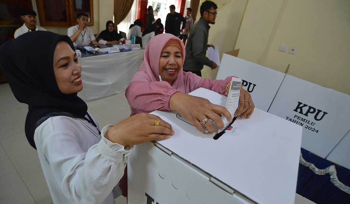 Petugas KPPS mendampingi warga memasukkan surat suara saat Pemungutan Suara Ulang (PSU) di TPS 03 Bukittinggi, Sumatera Barat, Sabtu (24/2).