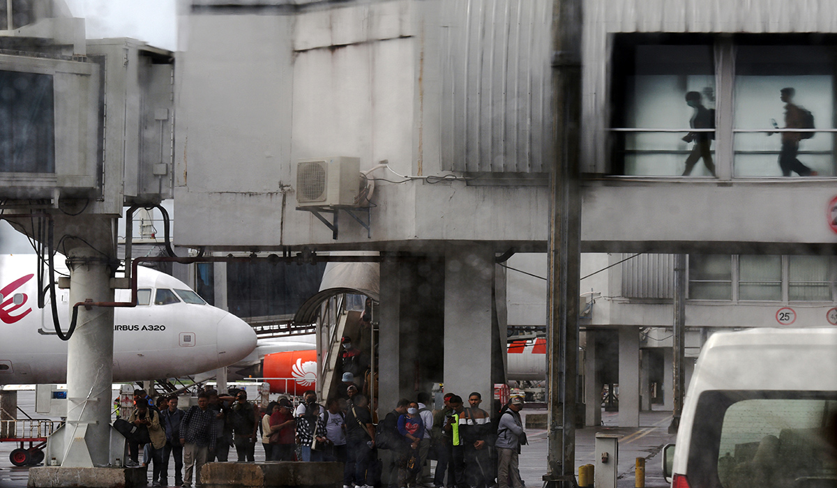 Penumpang menaiki pesawat di Bandara Internasional Sultan Hasanuddin, Makassar, Sulawesi Selatan, Selasa (16/1).