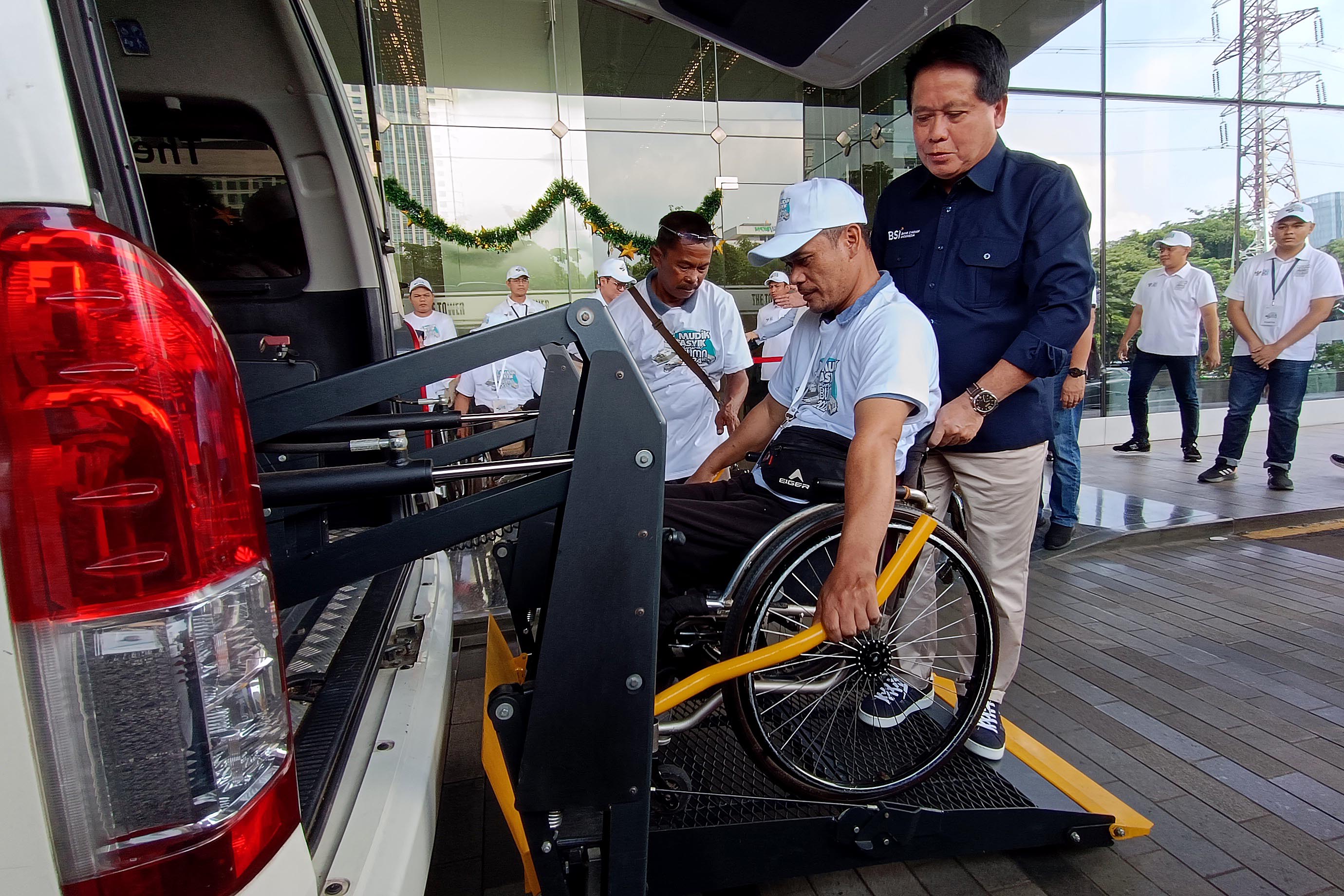 Direktur Utama BSI Hery Gunardi membantu pemudik difabel saat melepas mudik bareng di Jakarta, Jumat (5/4).