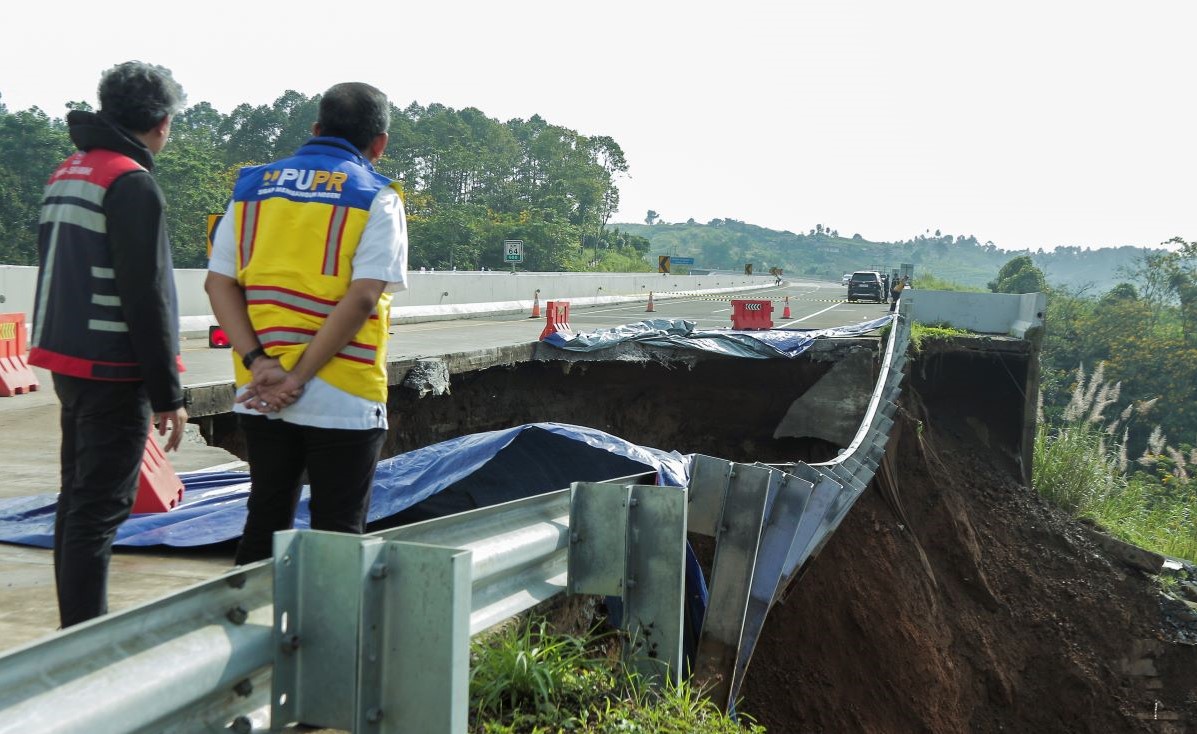 Petugas memeriksa kondisi jalan tol yang amblas di ruas tol Bocimi KM 64, Sukabumi, Jawa Barat 