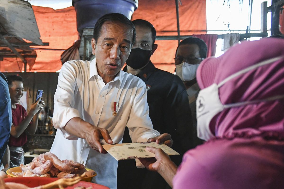 Presiden Jokowi membagikan bansos kepada pedagang.