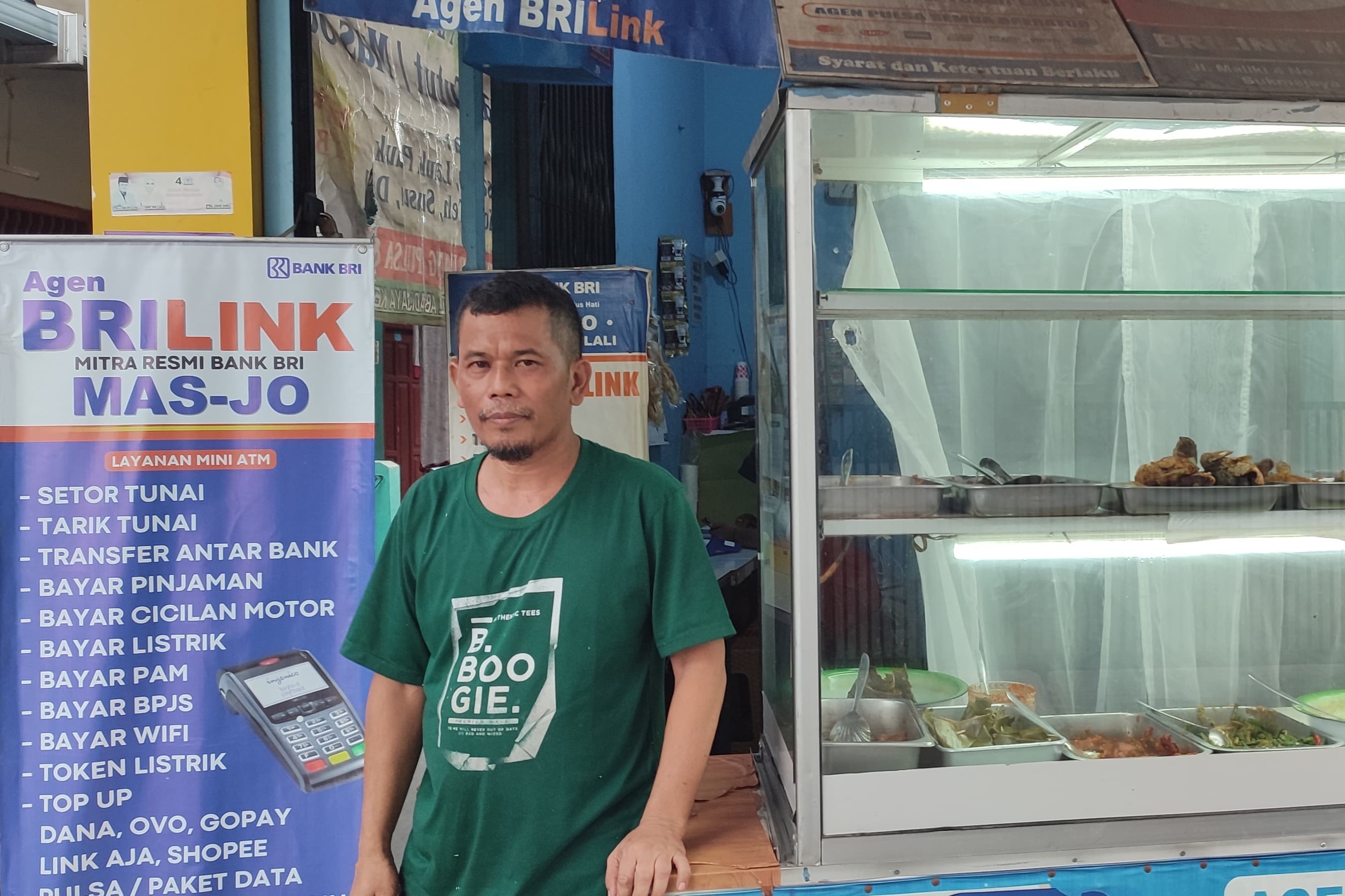 Sukarjo berdiri di depan kios dagangannya.