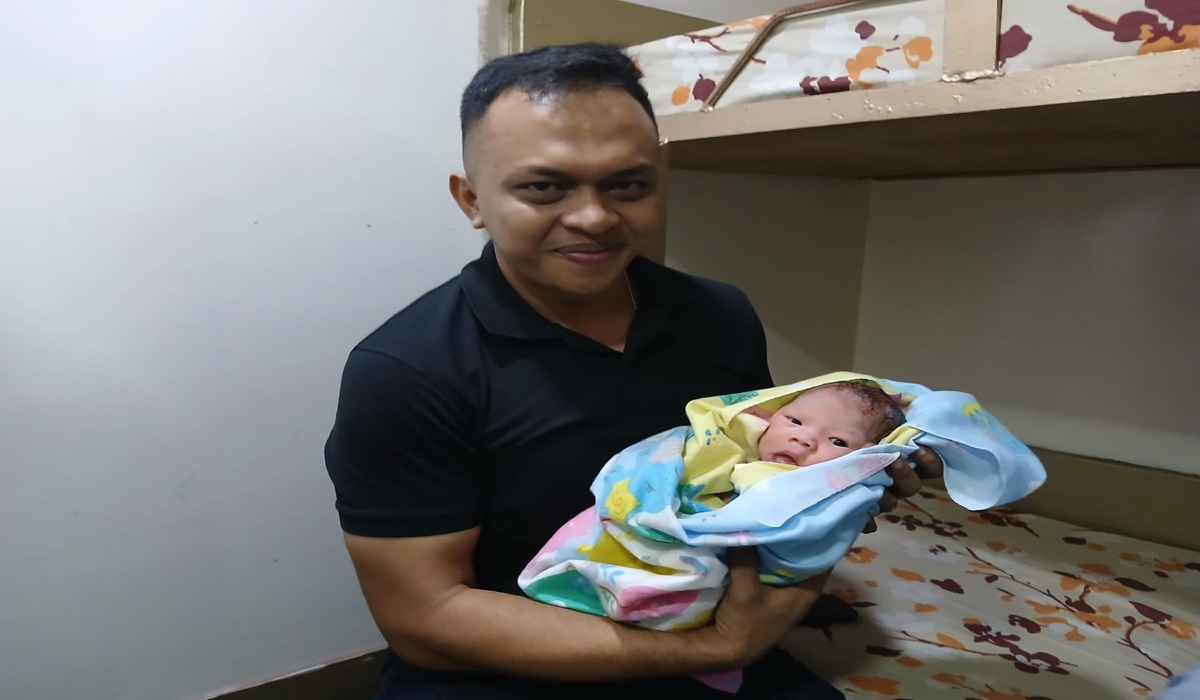 Dokter TNI AL Letda Laut (K) dr. Riezqi Bakrie bersama bayi yang dibantunya lahir di Kapal Penumpang Manado-Tahuna.