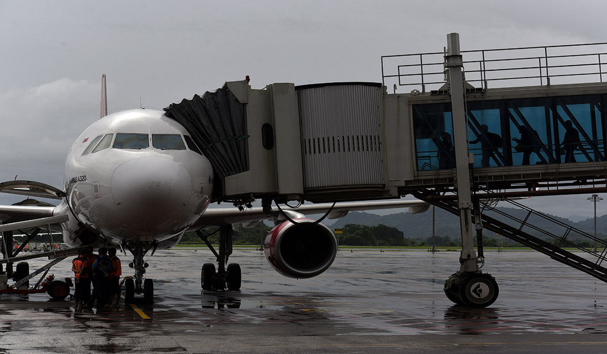 Penumpang menaiki pesawat di Bandara Internasional Sultan Hasanuddin, Makassar, Sulawesi Selatan, Selasa (16/1).