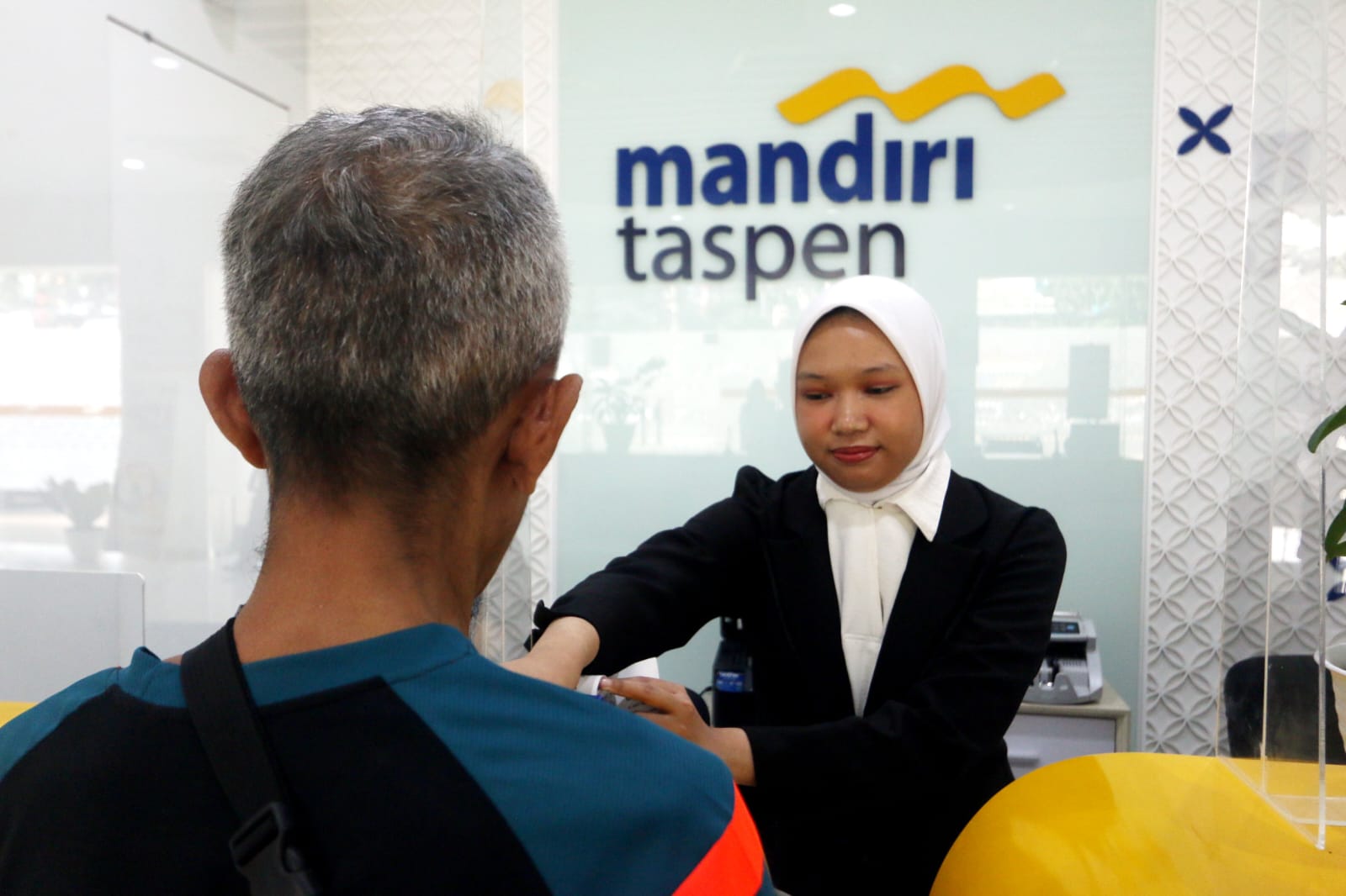 Karyawan Bank Mandiri Taspen sedang melayani nasabah saat melakukan transaksi di KCP Rawamangun, Jakarta, Rabu (23/4)