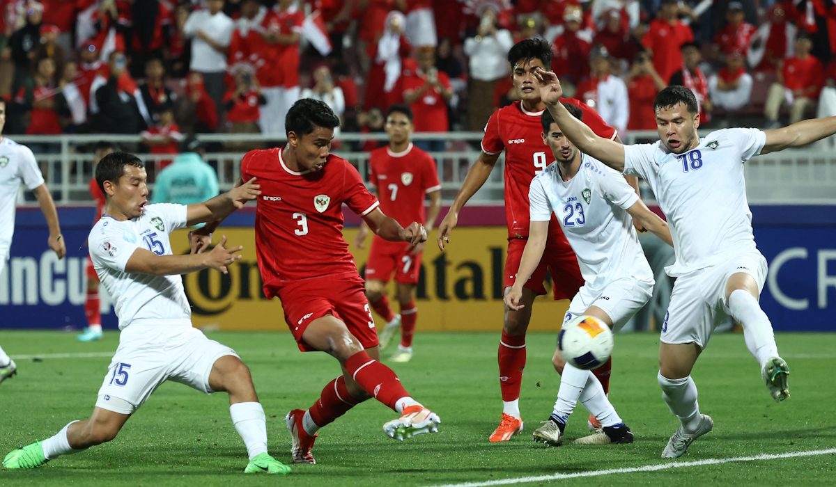 Bek Indonesia Muhammad Ferarri (2 kiri) dijaga oleh gelandang Uzbekistan Umarali Rakhmonaliev (kiri)