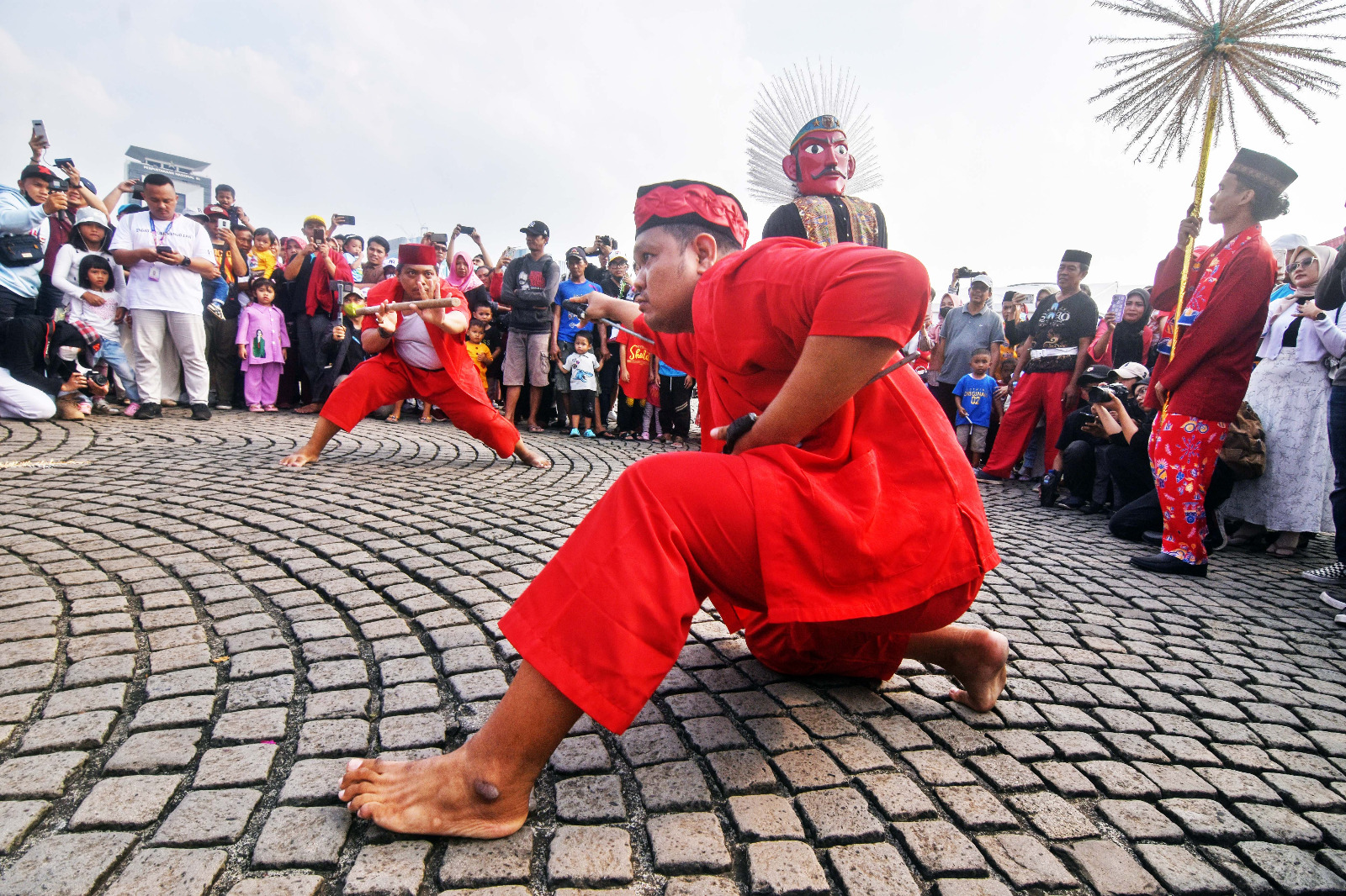 Masyarakat menyaksikan penampilan kesenian palang pintu pada gelaran Lebaran Betawi di kawasan Monumen Nasional (Monas), Jakarta.