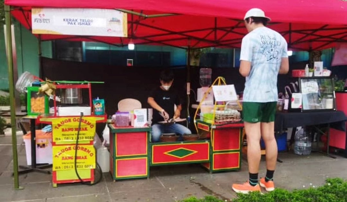 Ishak Yahya sedang melayani pembeli kerak telor
