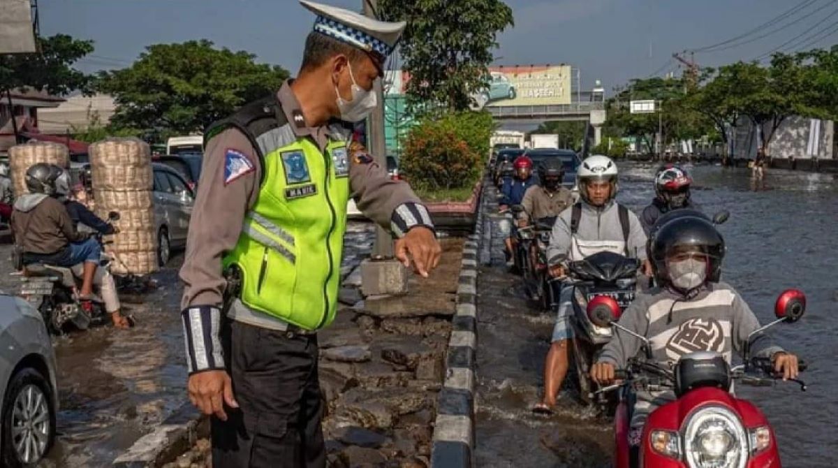 Pemudik menembus banjir di pantura Jateng.