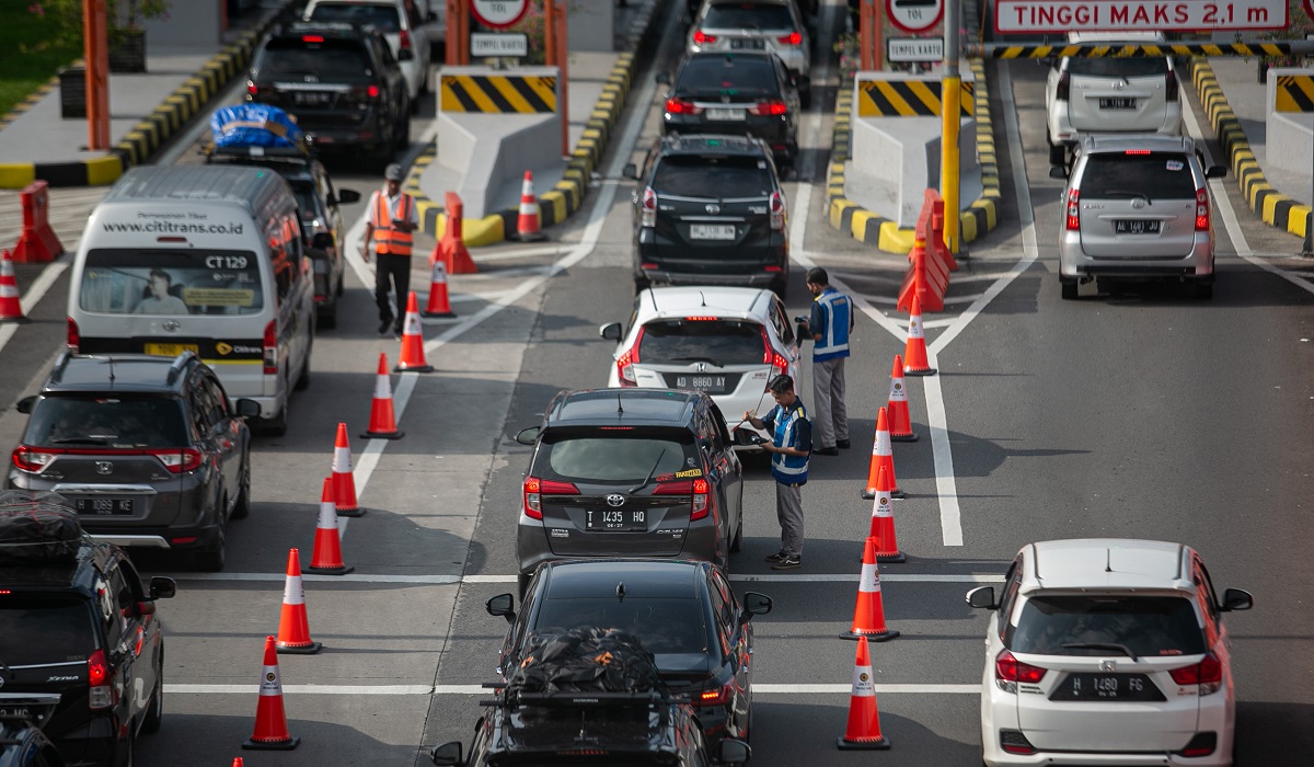 Petugas membantu pengemudi mobil membayar e-tol dengan portabel untuk memasuki pintu tol Colomadu, Karanganyar