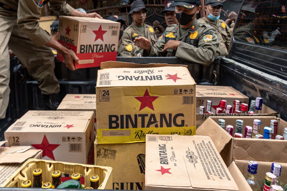 Petugas melakukan razia minuman keras.