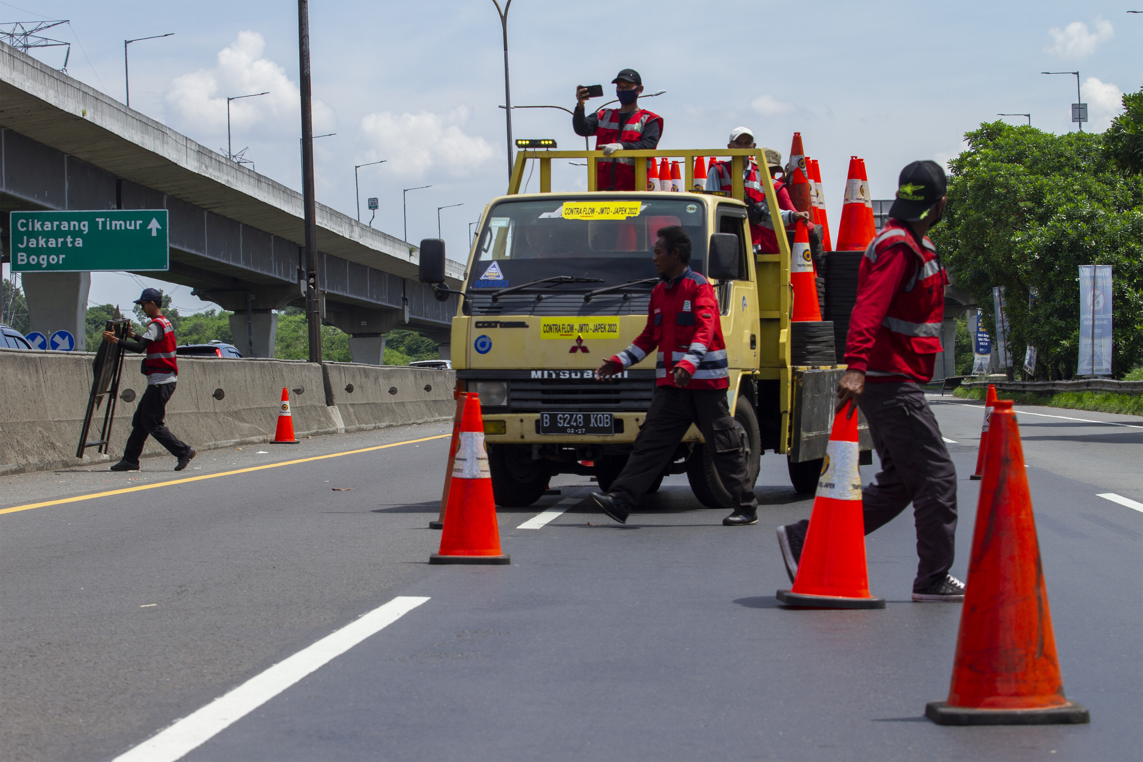 Petugas memasang pembatas jalan saat pemberlakuan 