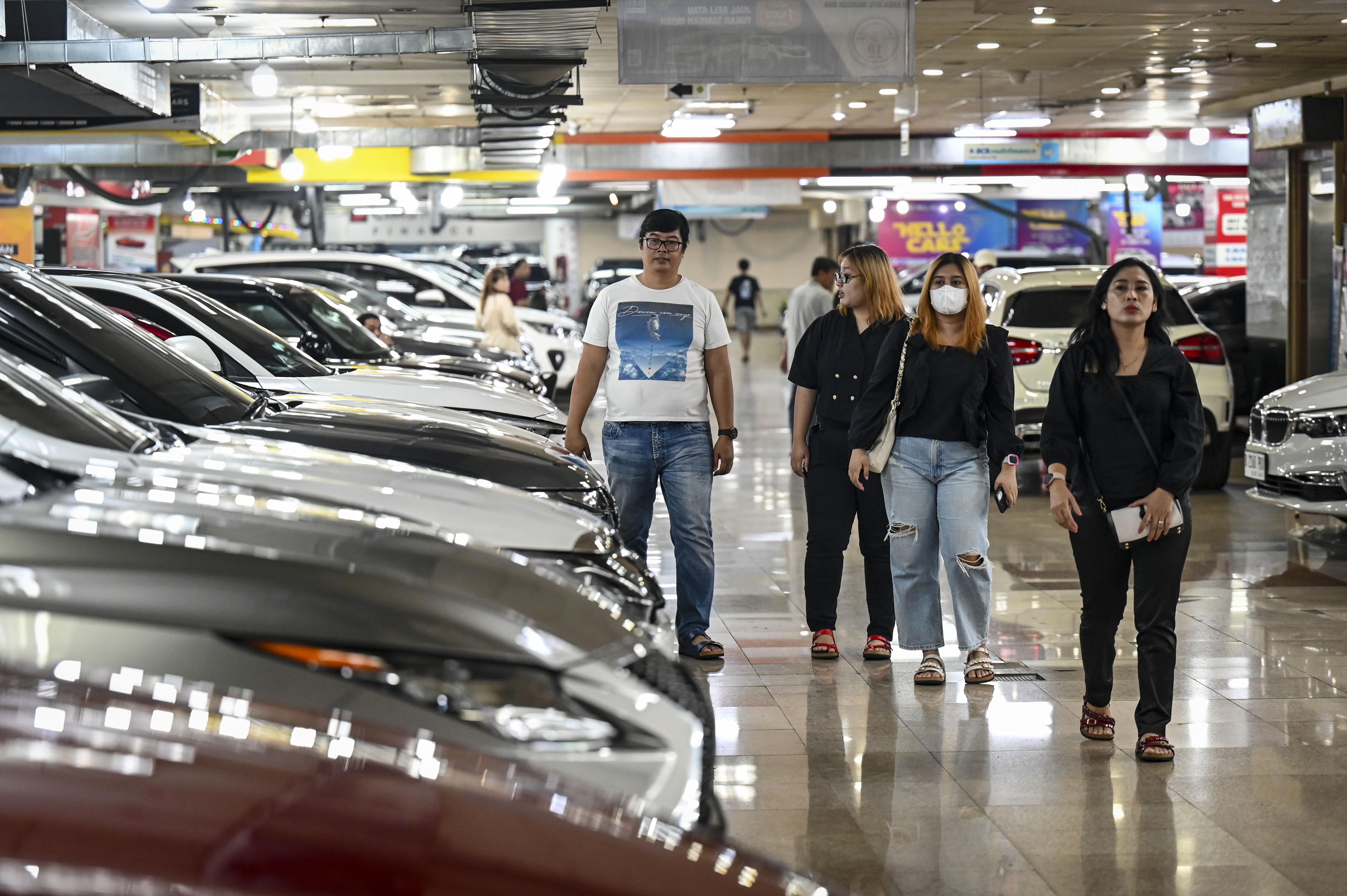 Sejumlah pengunjung melintas di samping deretan mobil bekas yang dijual di Bursa Mobil WTC Mangga Dua, Jakarta, Jumat (29/3/2024).