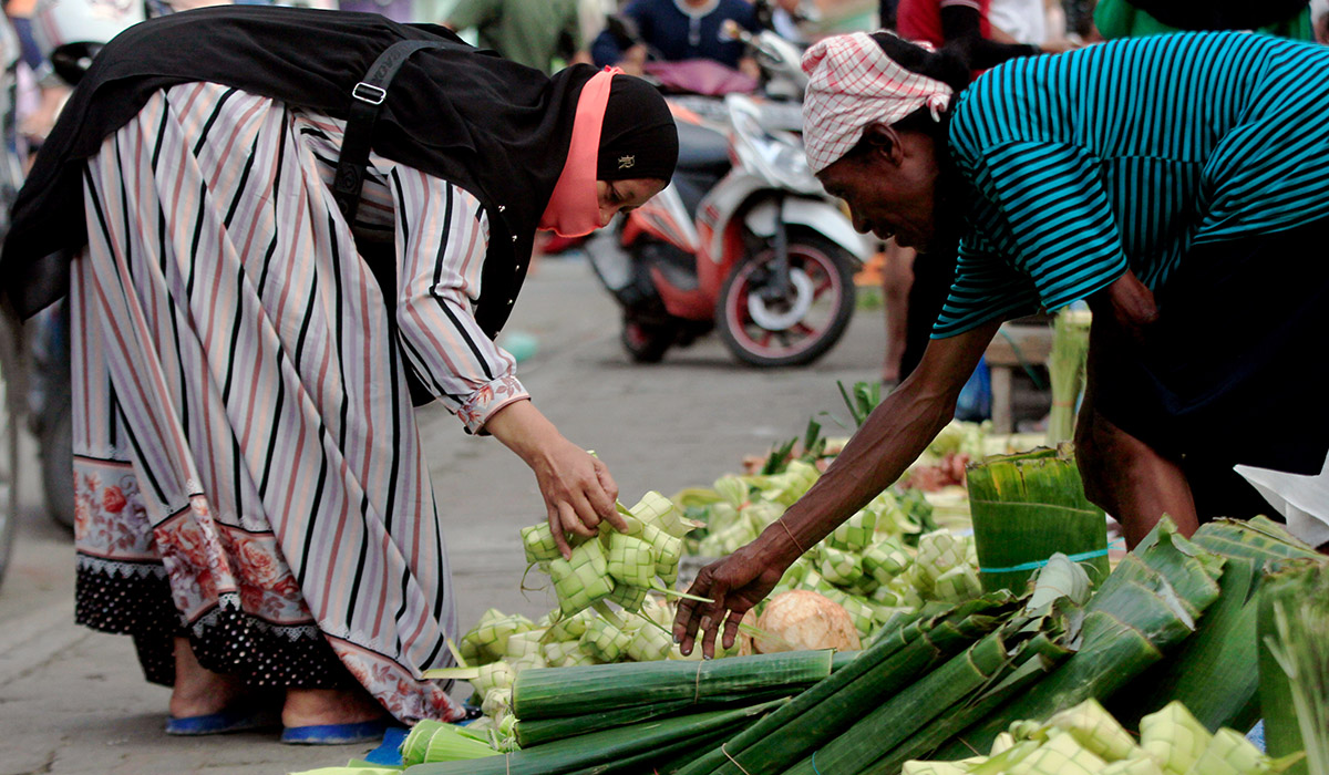 Pedagang melayani pembeli bungkus ketupat jelang Hari Raya Idul Fitri di Pasar Paldam, Jayapura, Papua, Minggu (1/5/2022).