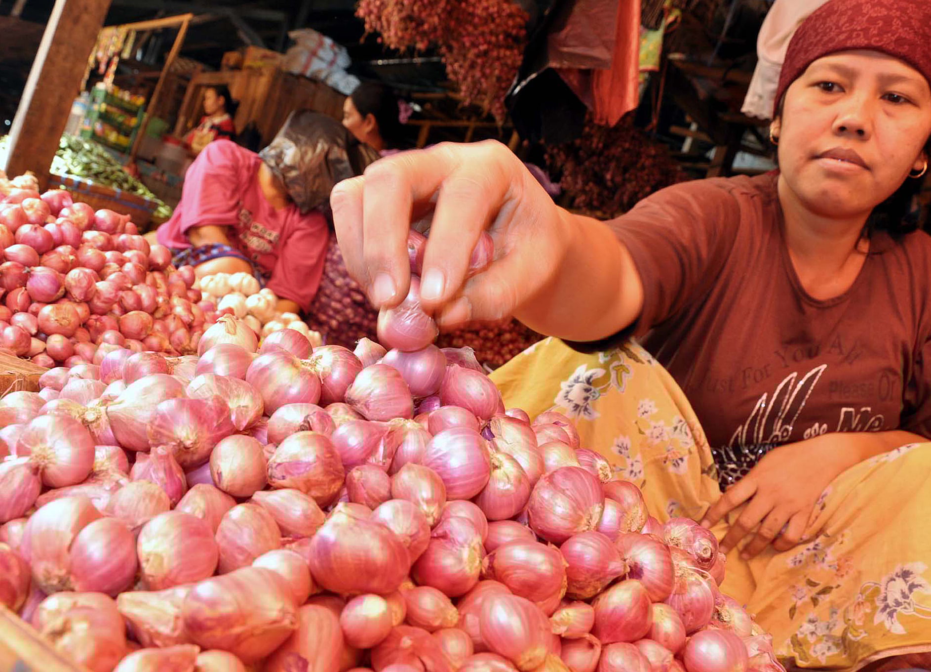 Pedagang bawang merah tengah melayani pembeli