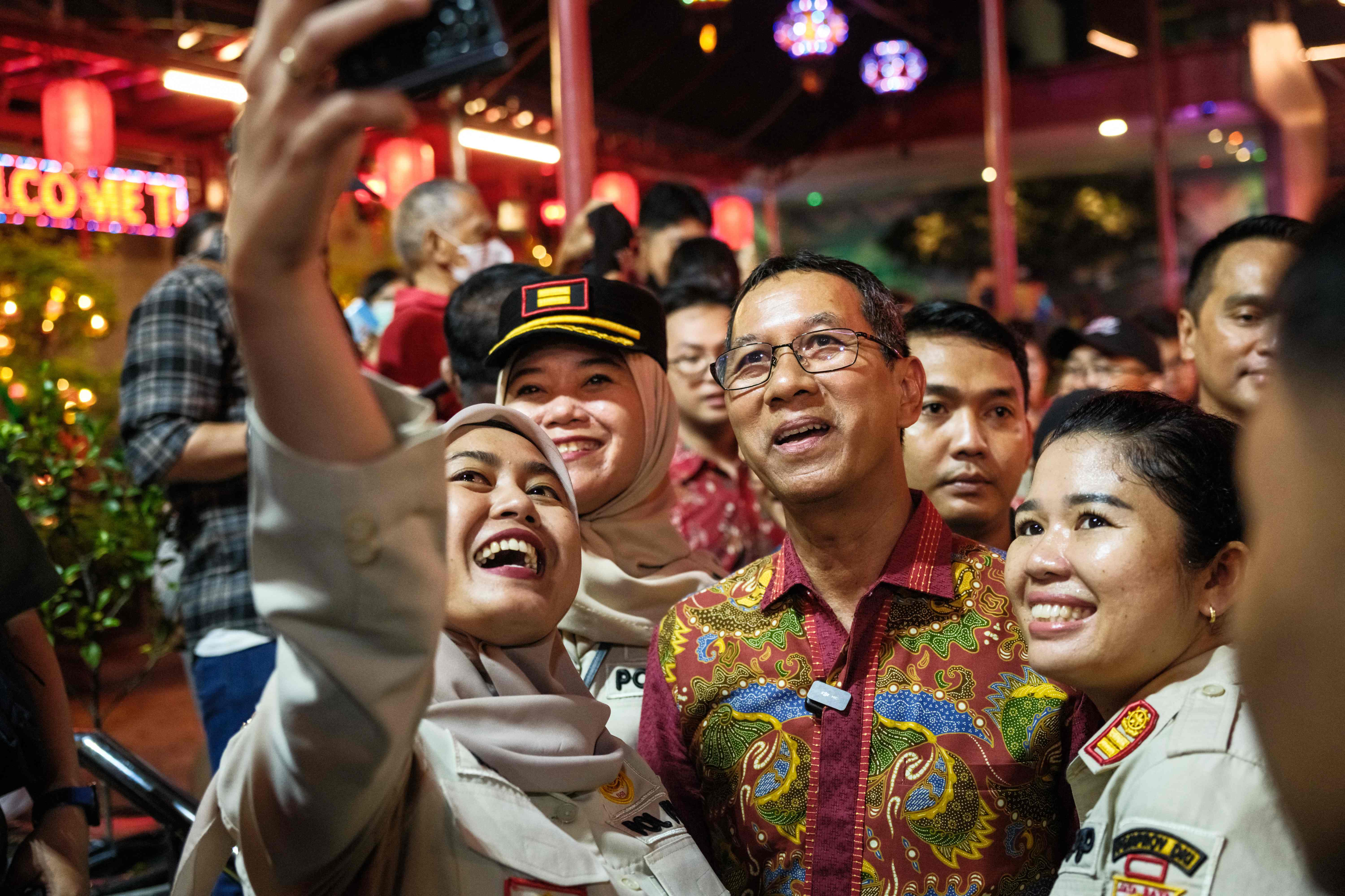 Penjabat Gubernur DKI Heru Budi Hartono (tengah) berswafoto bersama warga. 