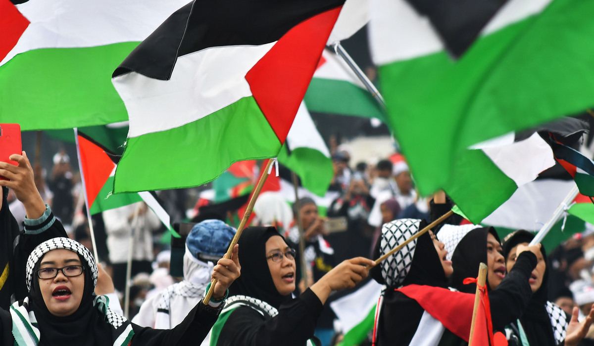 Sejumlah warga mengibarkan bendera Palestina saat mengikuti aksi Munajat Kubro 212 di Monas, Jakarta.