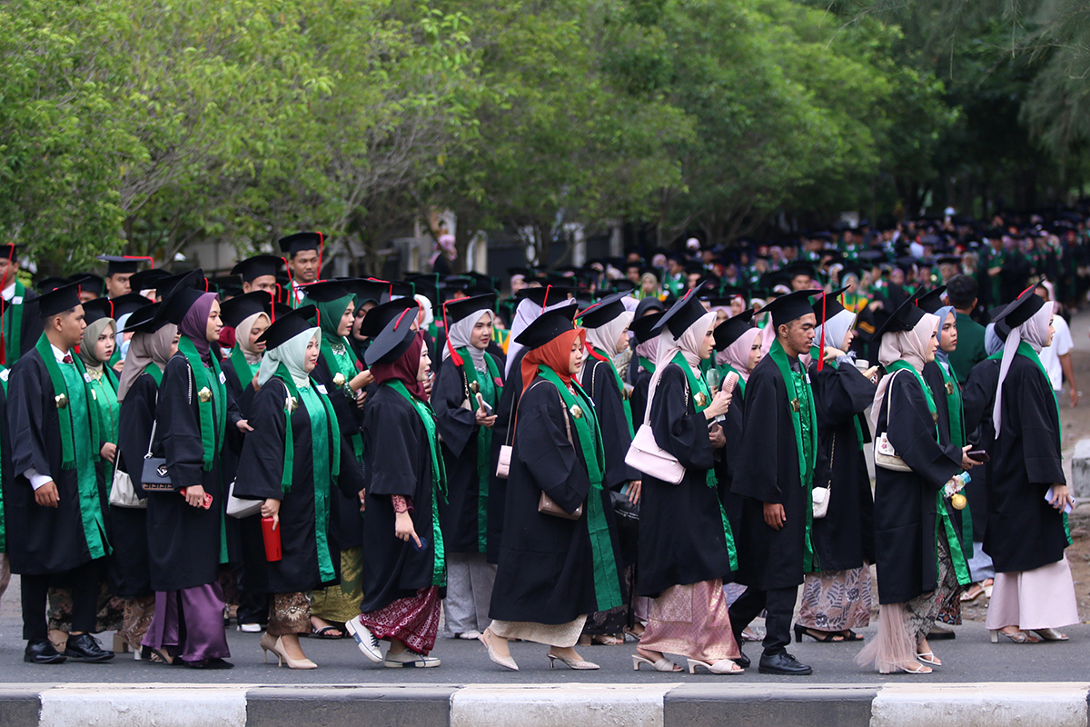 Para wisudawan berjalan memasuki gedung AAC Dayan Dawood untuk mengikuti upacara wisuda ke-161 USK, Rabu (15/5).