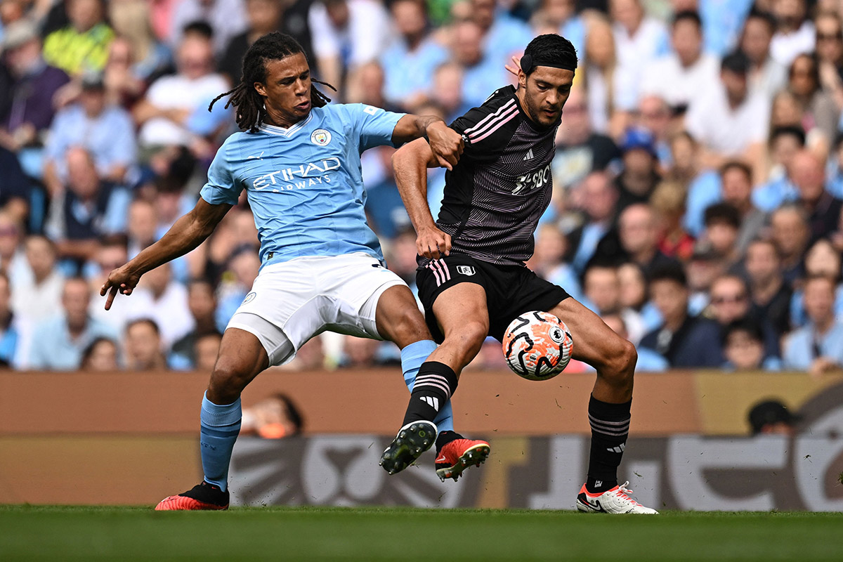 Pemain Manchester City Nathan Ake (kiri) berebut bola dengan striker Fulham Raul Jimenez.