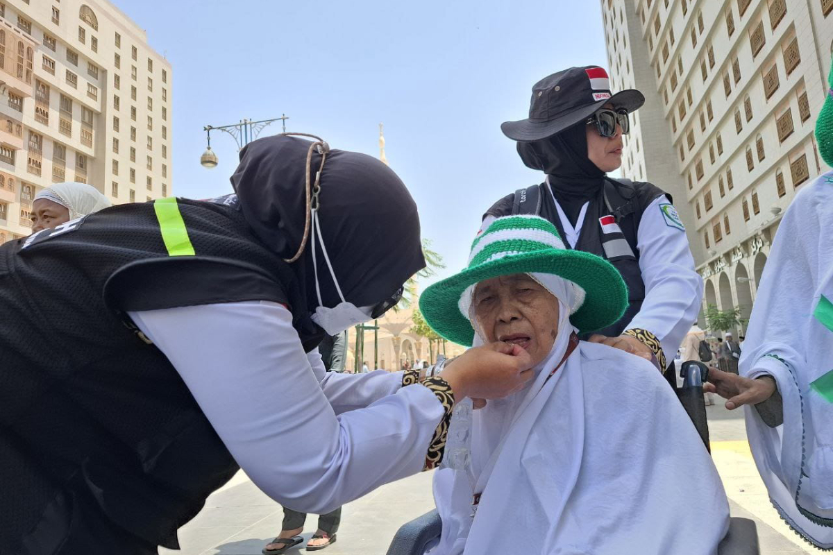  Petugas haji tusi PKP3JH dan Linjam sedang memberikan obat kepada jemaah. Diketahui jemaah yang berusia 73 tahun tersebut sakit gangguan pa