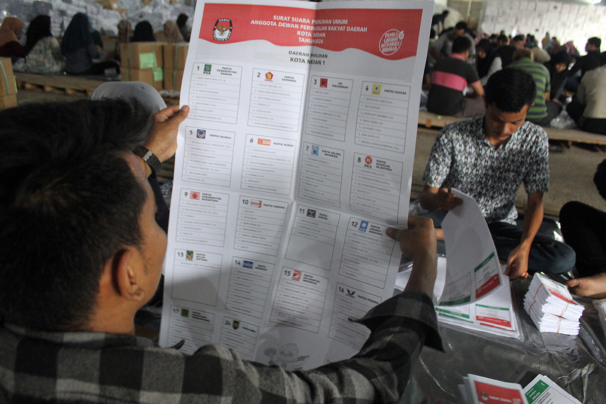 Sejumlah pekerja melipat surat suara Pemilu 2024.