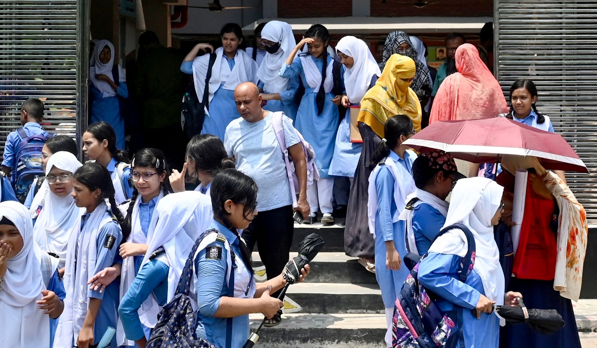 Siswa meninggalkan halaman sekolah membawa payung pada hari musim panas di Dhaka