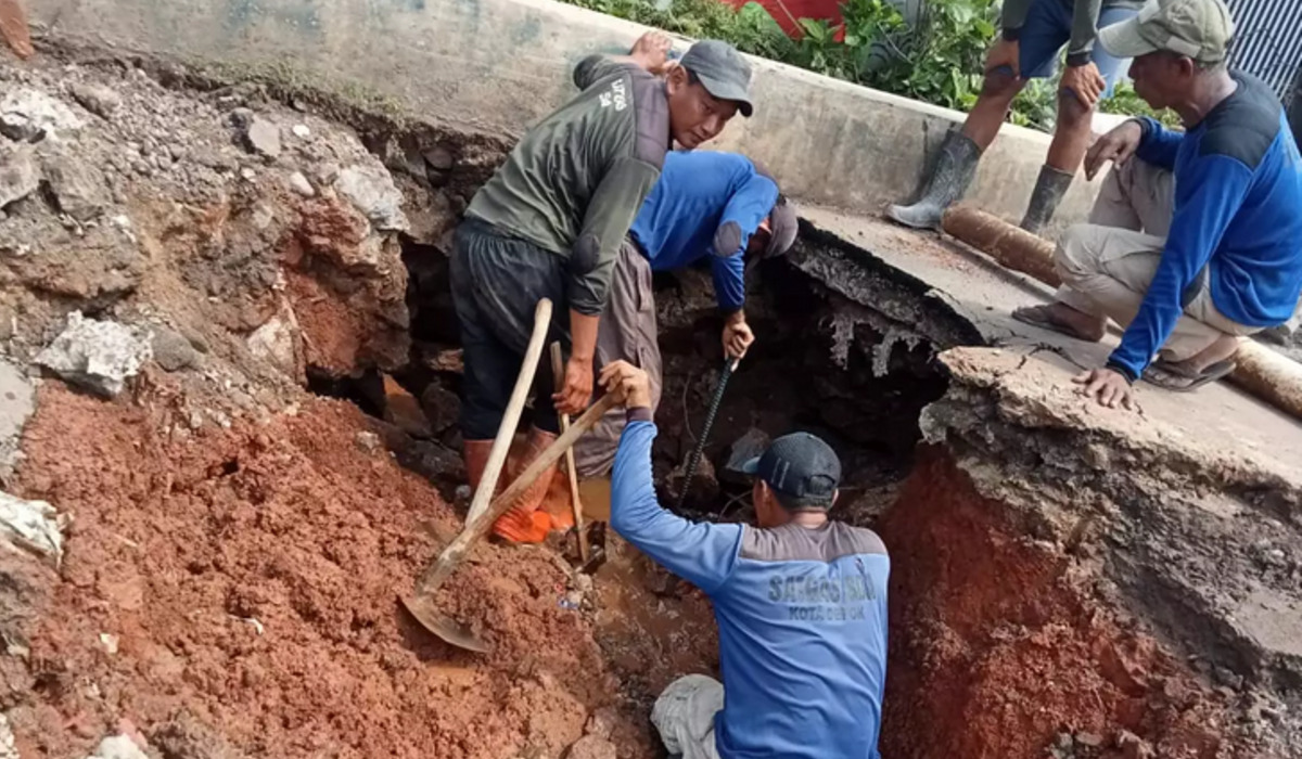 Penanganan jalan amblas di Jalan Enggram Raya RT 06 RW 05 Kelurahan Sawangan Baru, Kecamatan Sawangan, Depok.