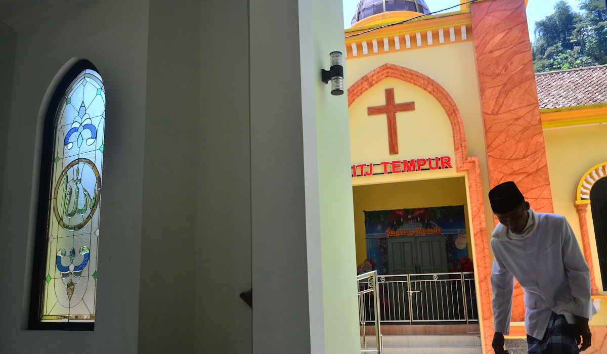 Umat Islam berjalan memasuki Masjid Nurul Hikmah (kiri) yang berhadapan dengan Gereja Injil Tanah Jawa (GITJ) di Jepara