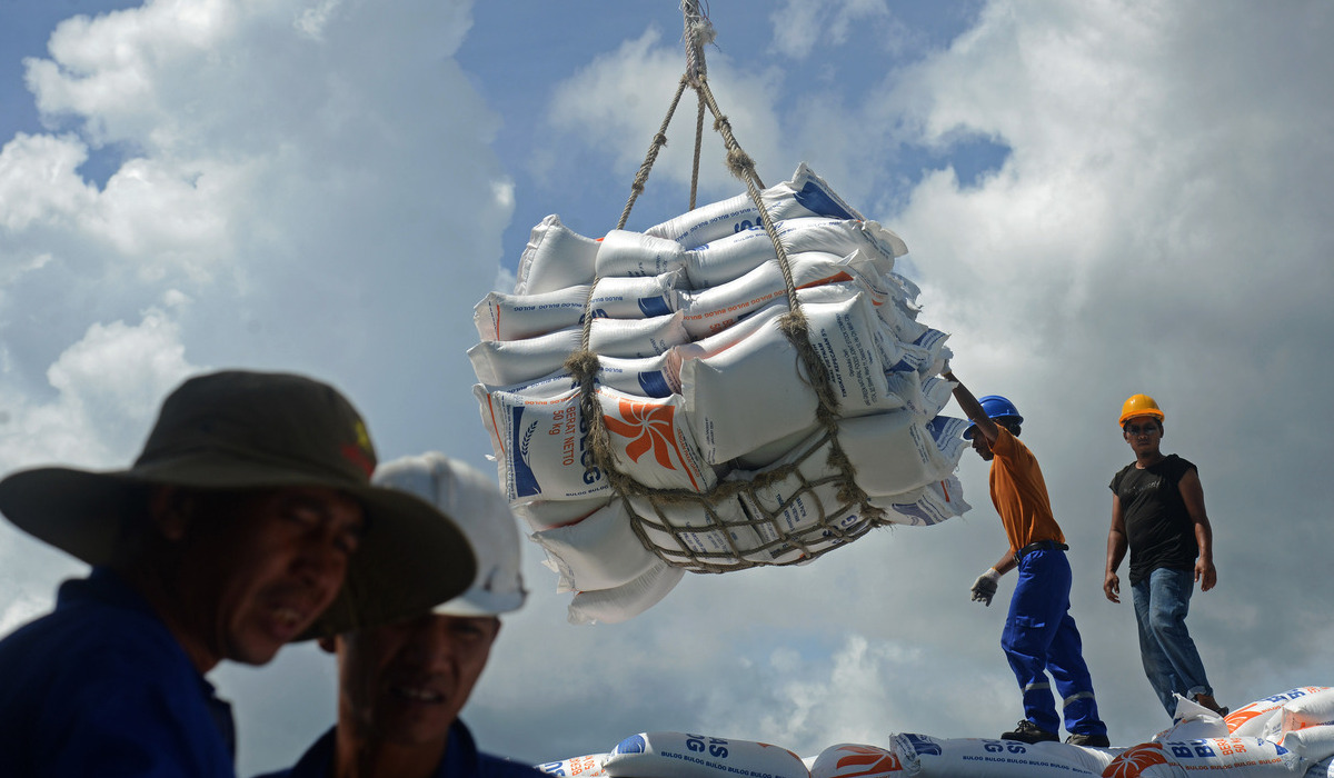 Petugas menurunkan beras impor yang datang ke dalam negeri.