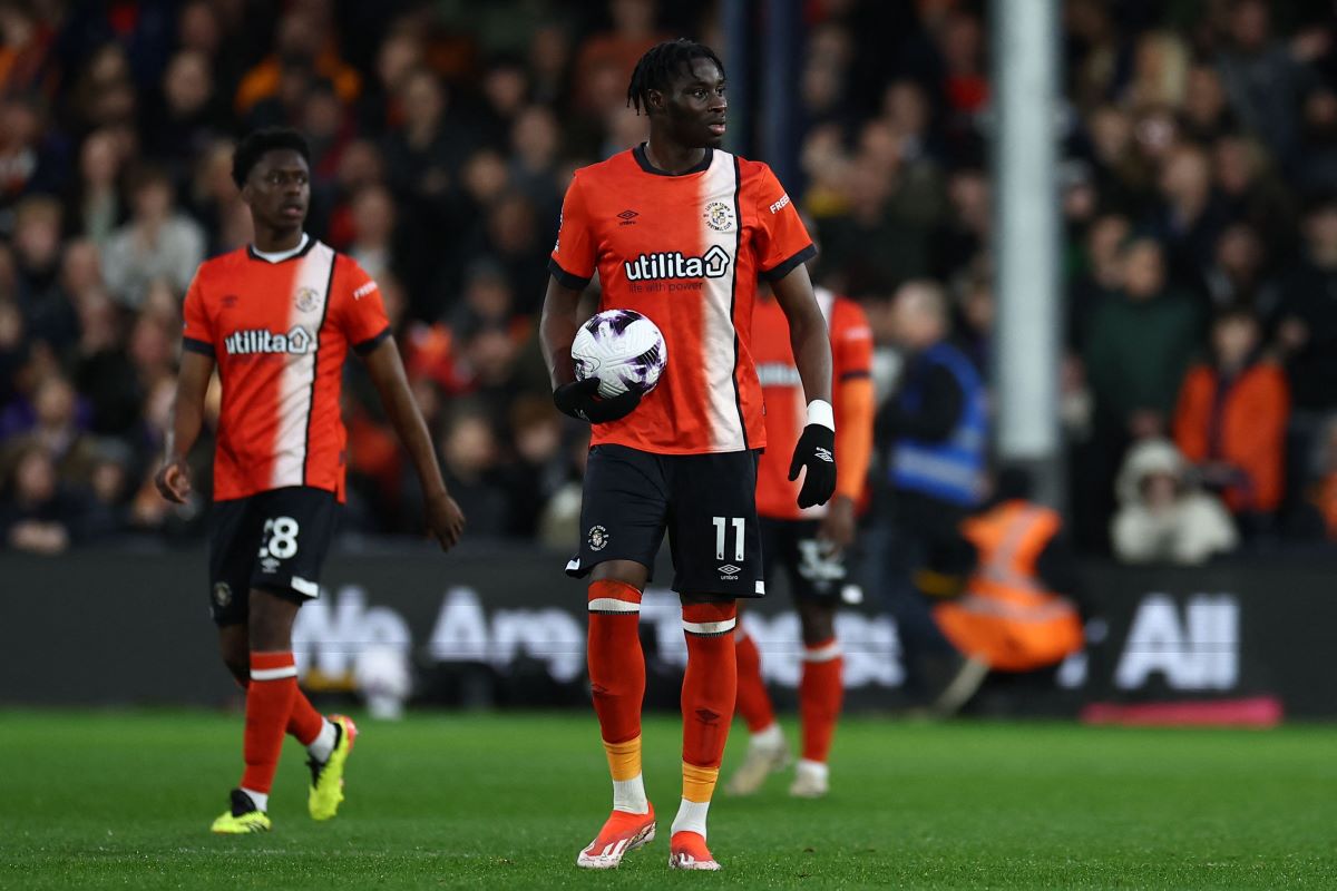 Striker Luton Town Elijah Adebayo memegang bola usai mencetak gol ke gawang Everton.