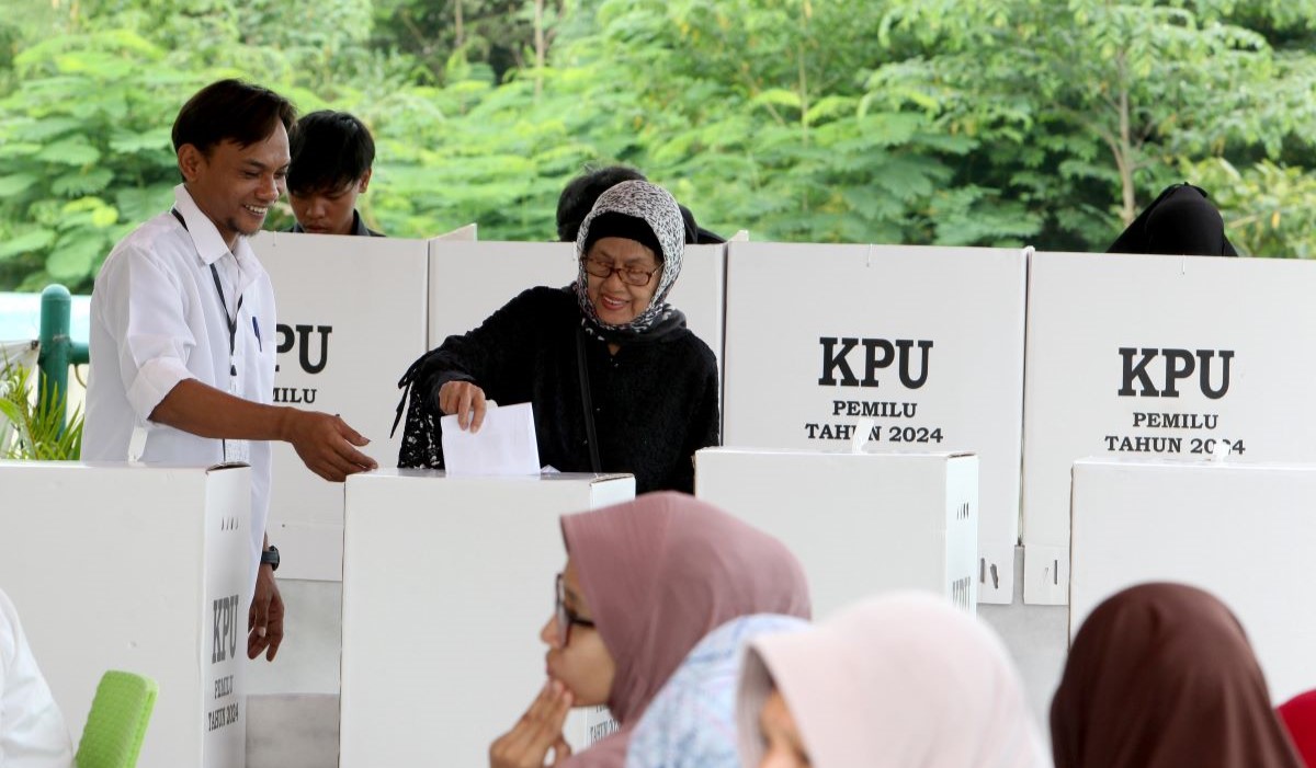 Ilustrasi: warga dibantu anggota KPPS memberikan hak suaranya di TPS 