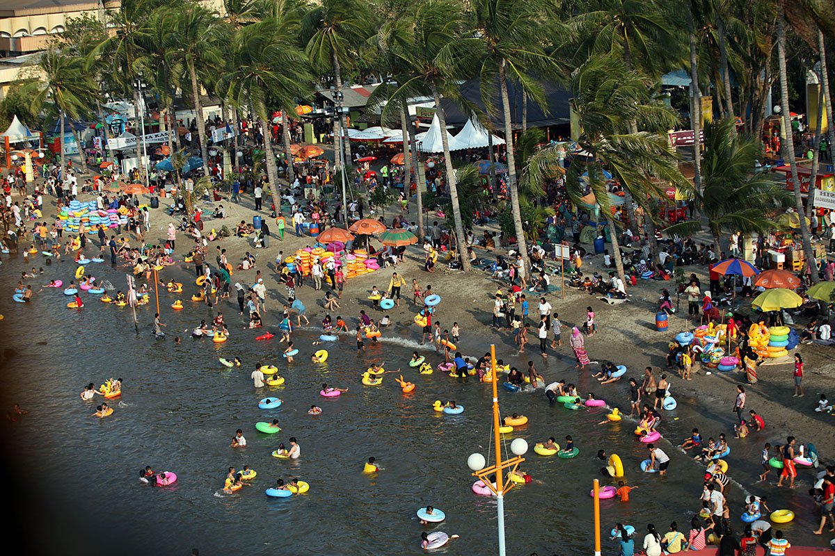 Pengunjung berenang di pantai kawasan rekreasi Ancol, Jakarta Utara, Rabu (31/8/2011).