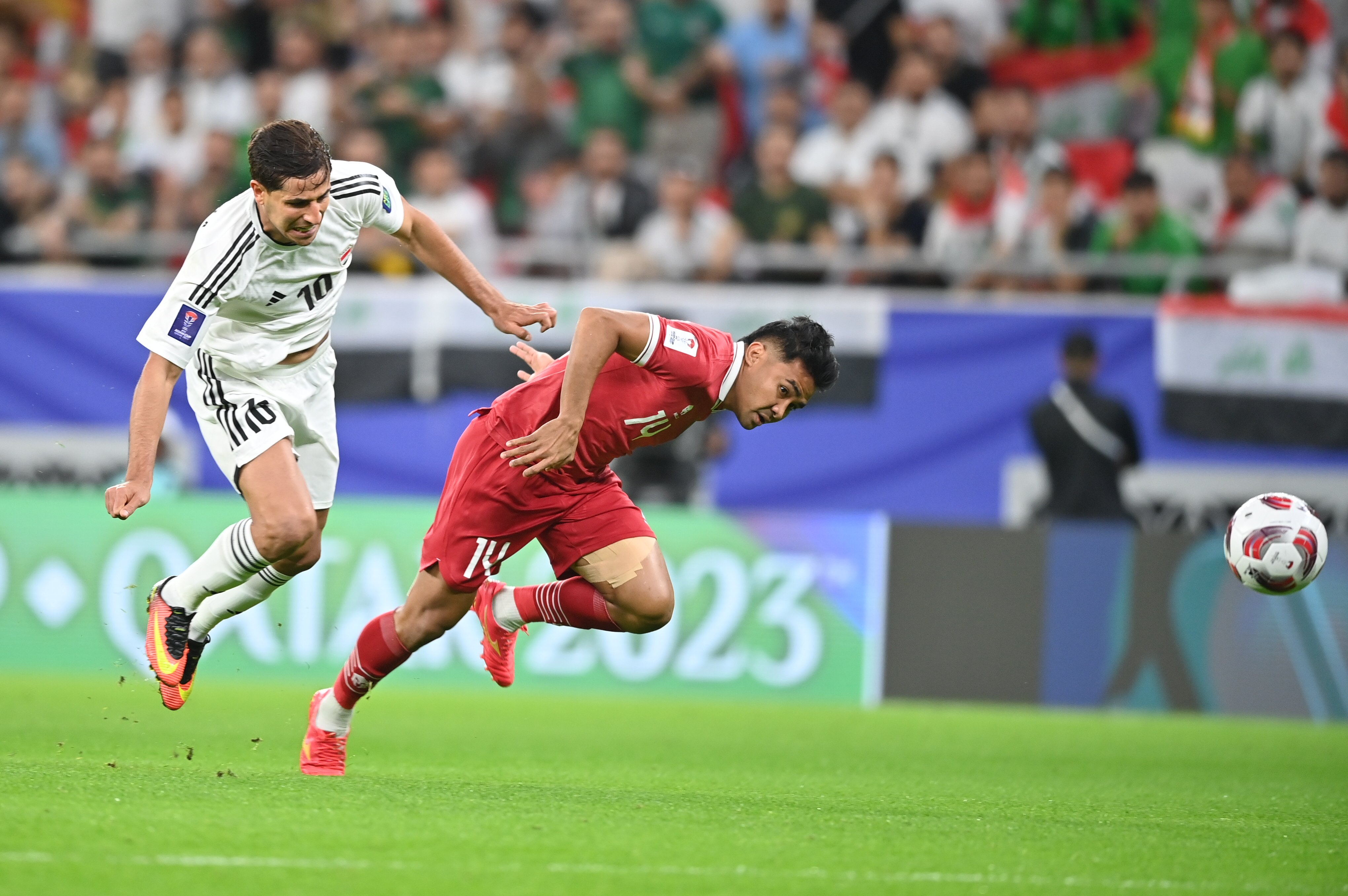  Pemain Timnas Indonesia Asnawi Mangkualam Bahar(kanan) berebut bola dengan Pemain Irak Mohanad Ali Kadhim. 