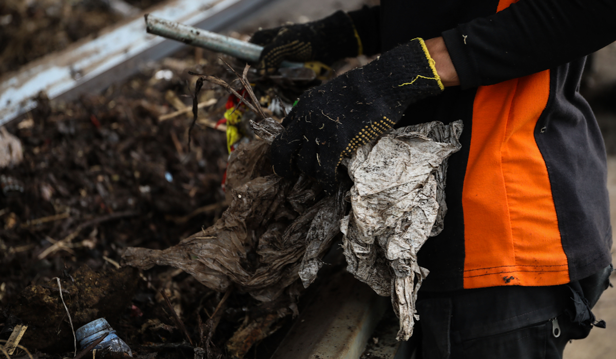 Petugas UPK Badan Air DLH Provinsi DKI Jakarta memilah cacahan sampah plastik dan bambu APK
