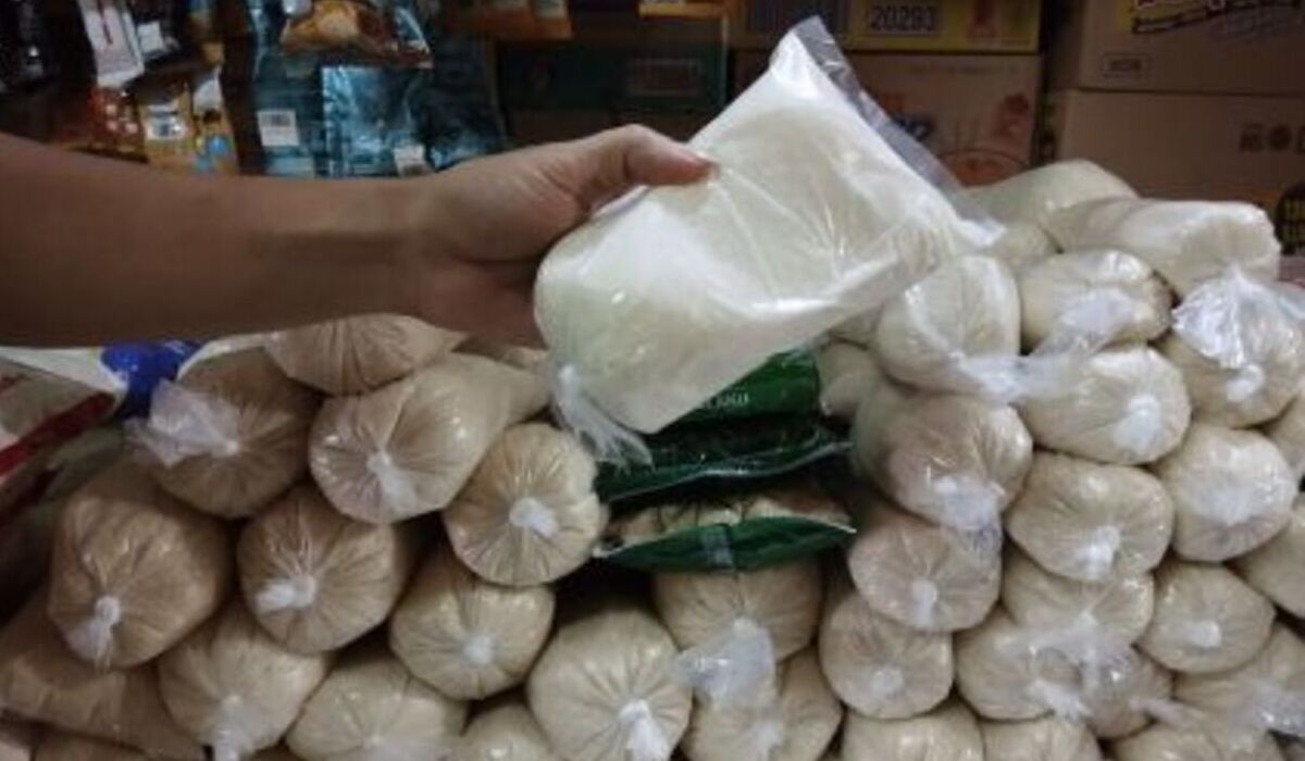 Pedagang menunjukkan gula pasir yang dijual di pasar tradisional.